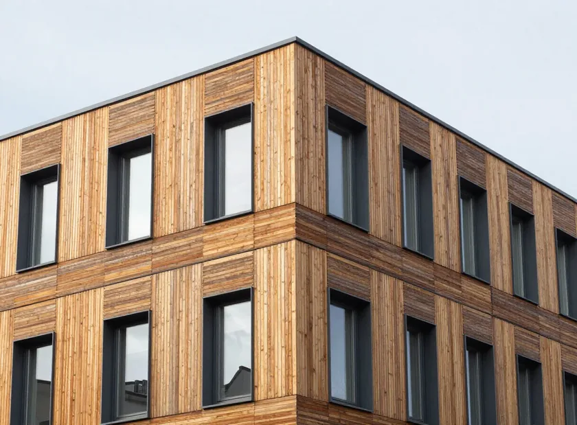 Holzfassade mit senkrechter Gliederung und Fensteröffnungen